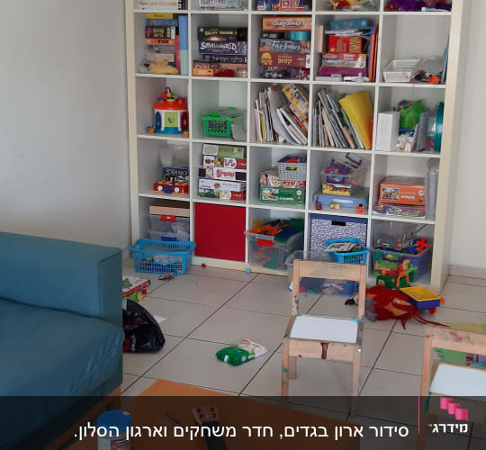 מדפים עם משחקי קופסה, צעצועים וספרים בחדר ילדים